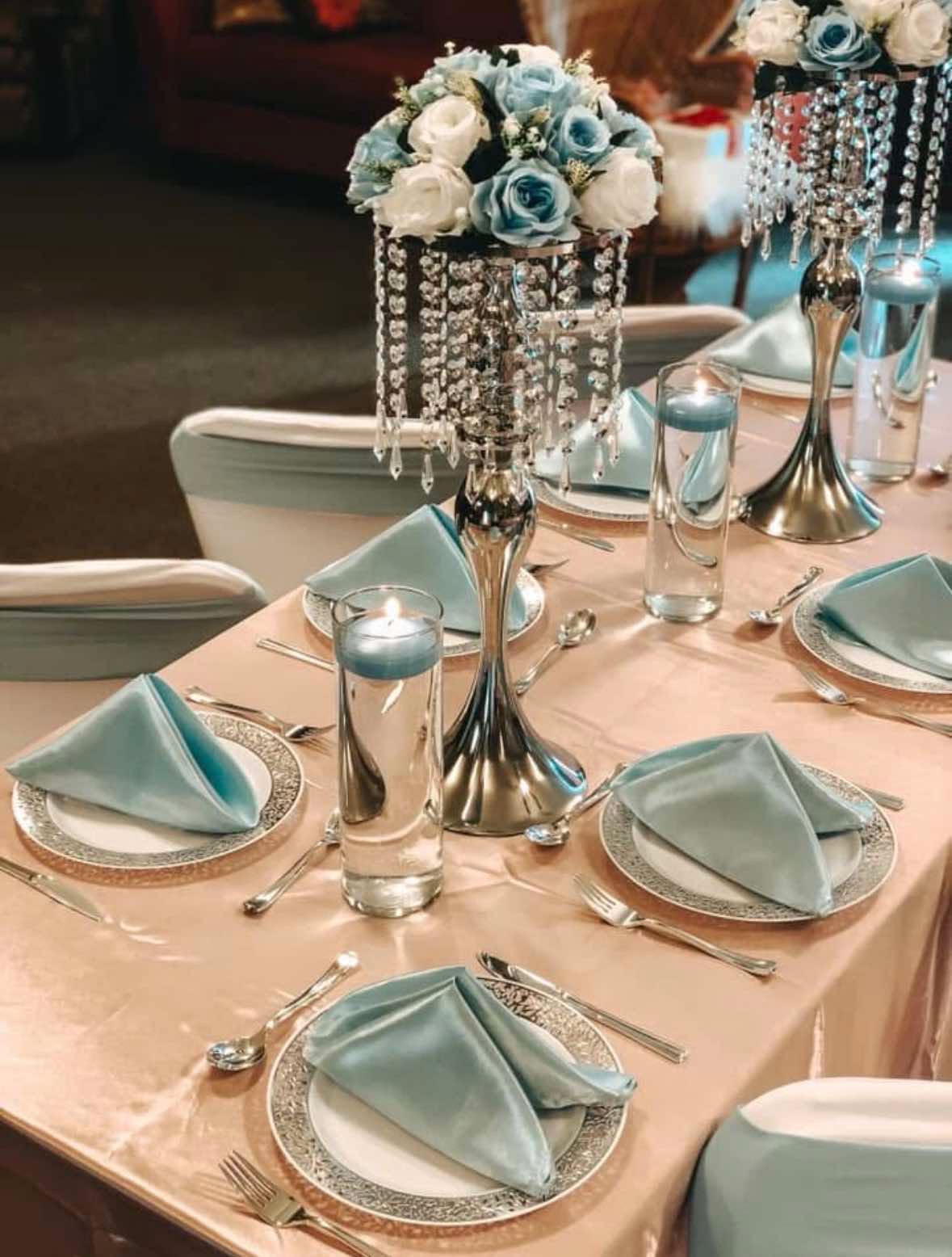 Elegant blue and silver tablescape with crystal candelabra and roses