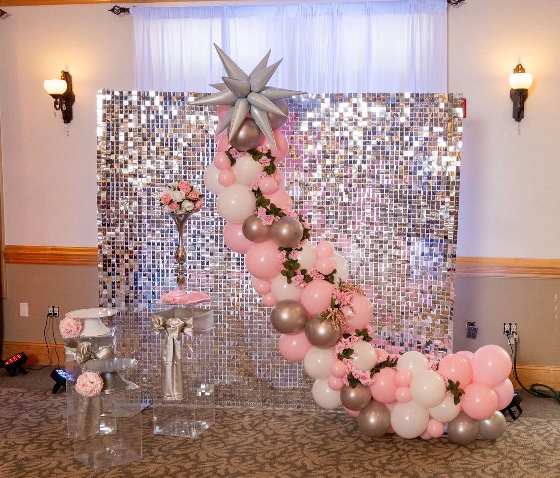 Glam balloon garland with silver shimmer wall and floral accents