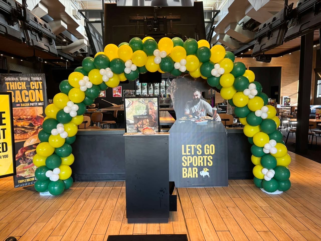 Green and yellow balloon arch for a sports bar fight night event