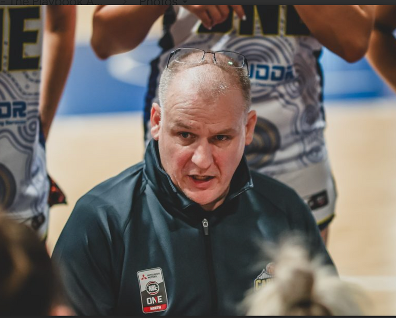 Australian basketball coach addressing the team in a huddle