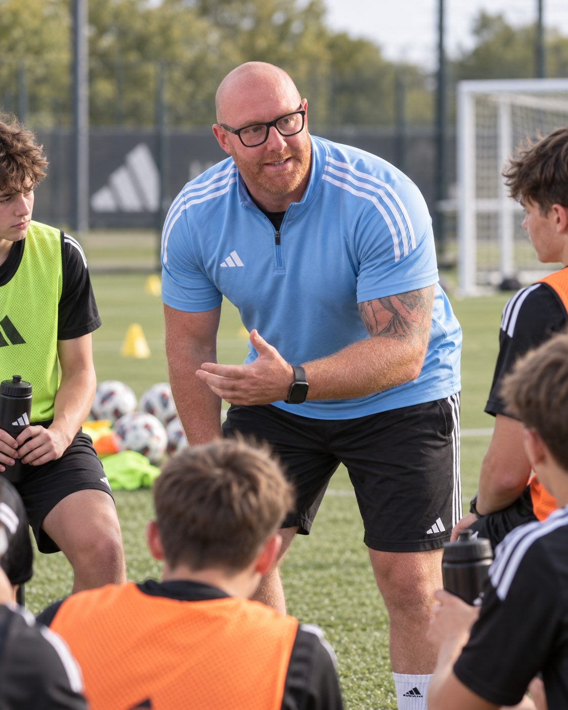 Ben speaking with youth football players during a coaching session.