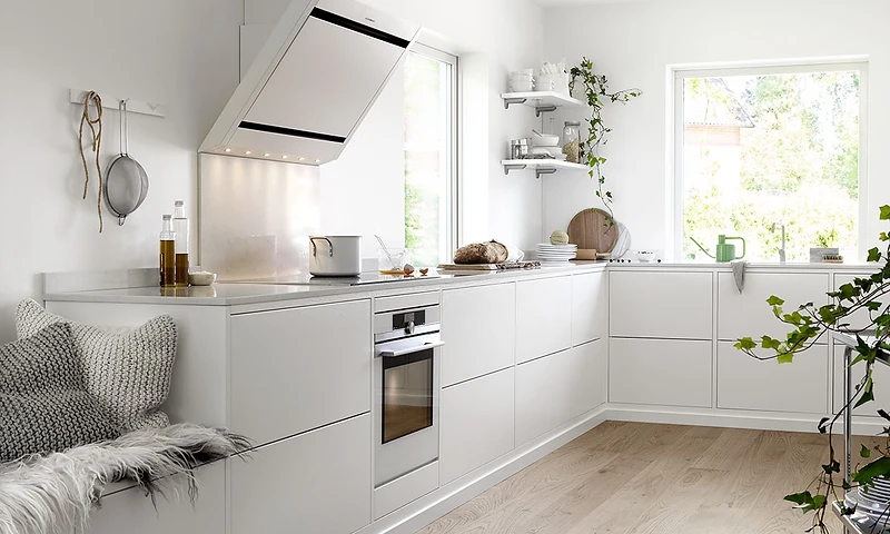 L-format kök i vit finish med ekparkett och stora fönster