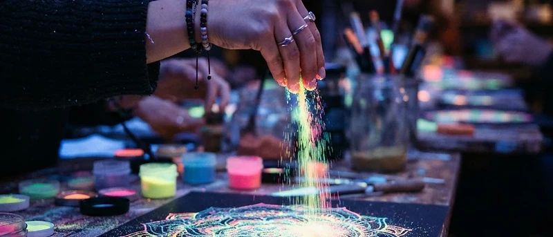 UV-leuchtende Sandbilder bei Nacht