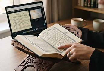 An open Quran with a cream bookmark resting on a green cloth