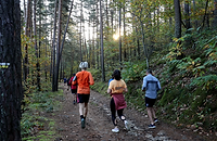 Participants courant sur un sentier forestier