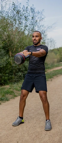 Nacer réalise un exercice avec une kettlebell en extérieur