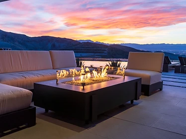 American Fyre Designs Iron Saddle rectangular fire pit with glass wind guards at sunset