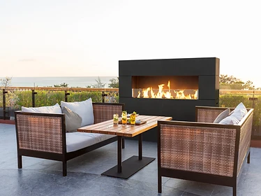 American Fyre Designs Milan Tall fireplace on an outdoor terrace overlooking the ocean