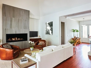 Astria Allume 60 linear gas fireplace set into floor-to-ceiling gray tile surround