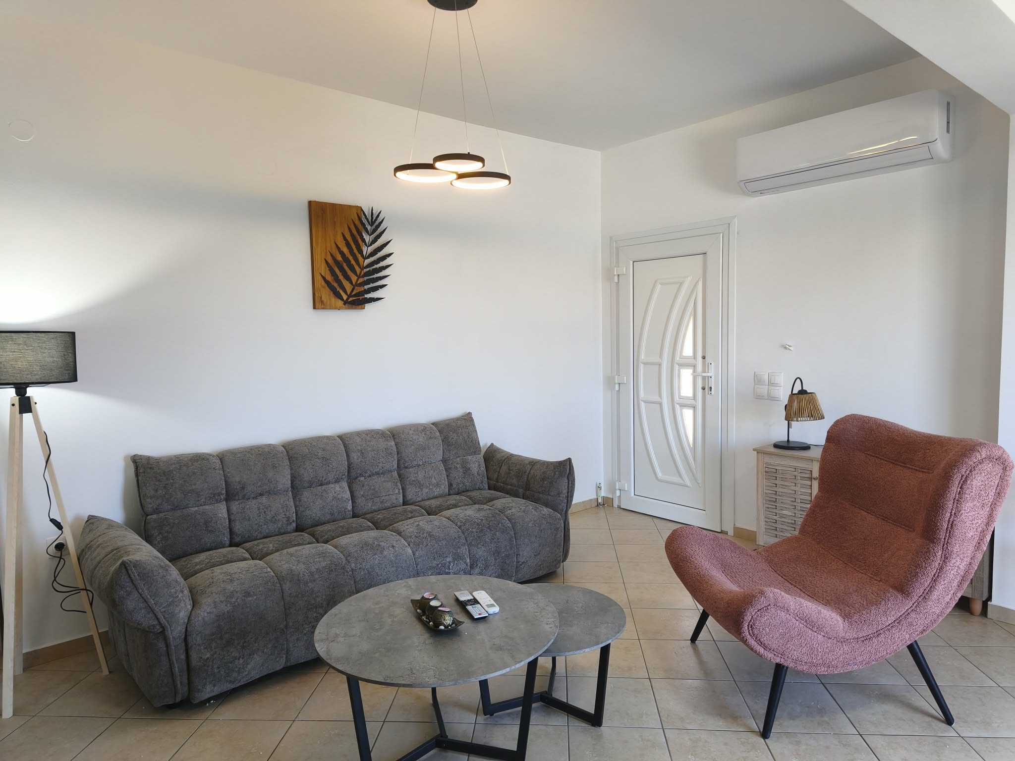 Living room with grey sofa, pink armchair & nesting tables