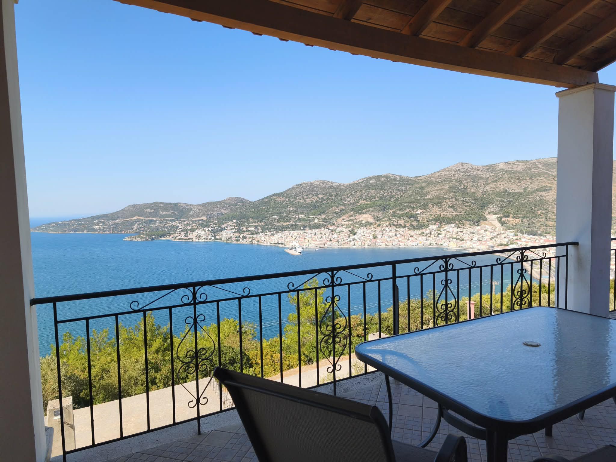 Terrace with dining table, string lights & sea view