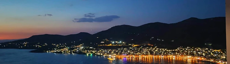 Twilight view of the harbor town from a hillside balcony