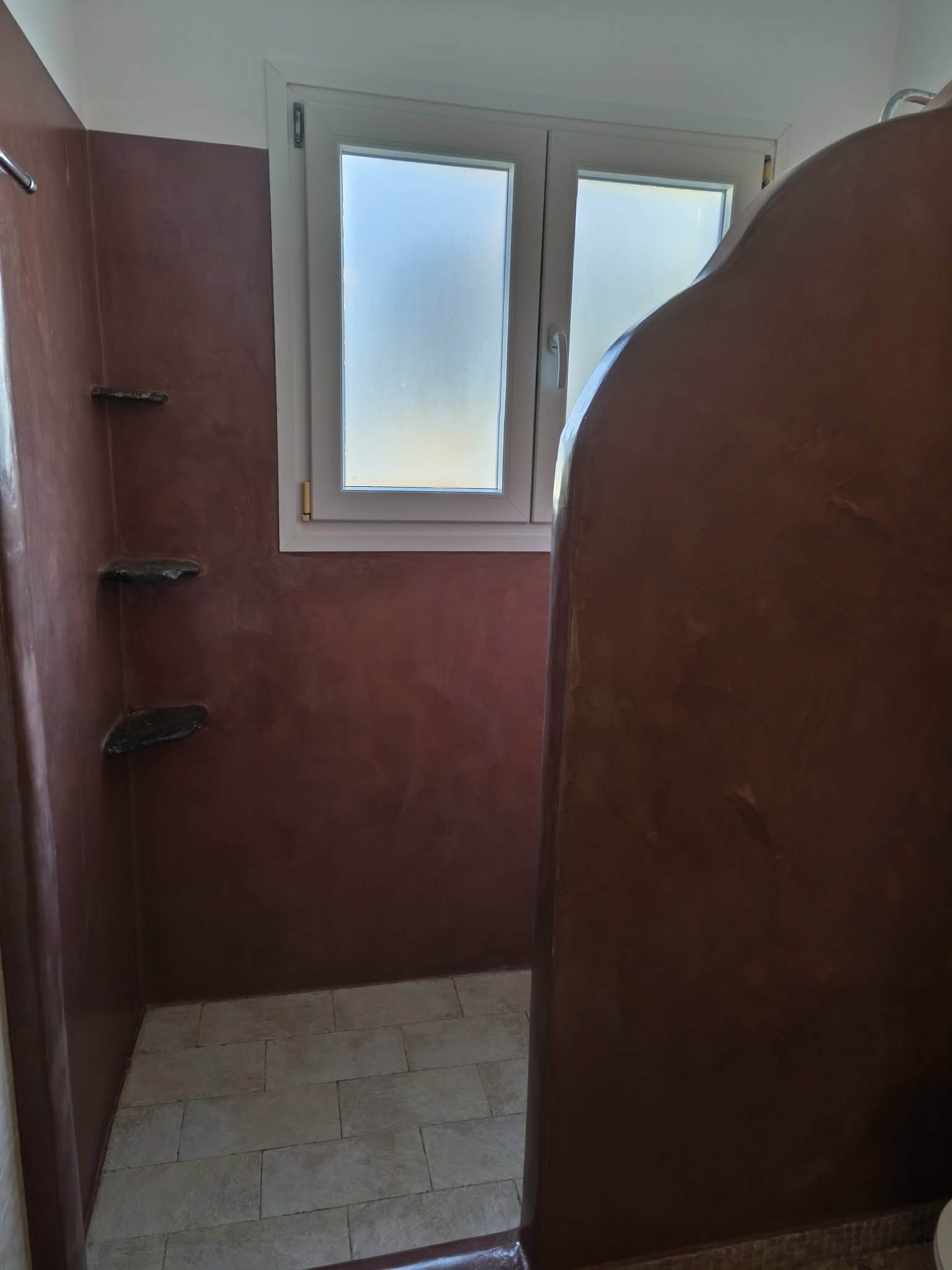 Shower stall with terracotta plaster & stone shelves