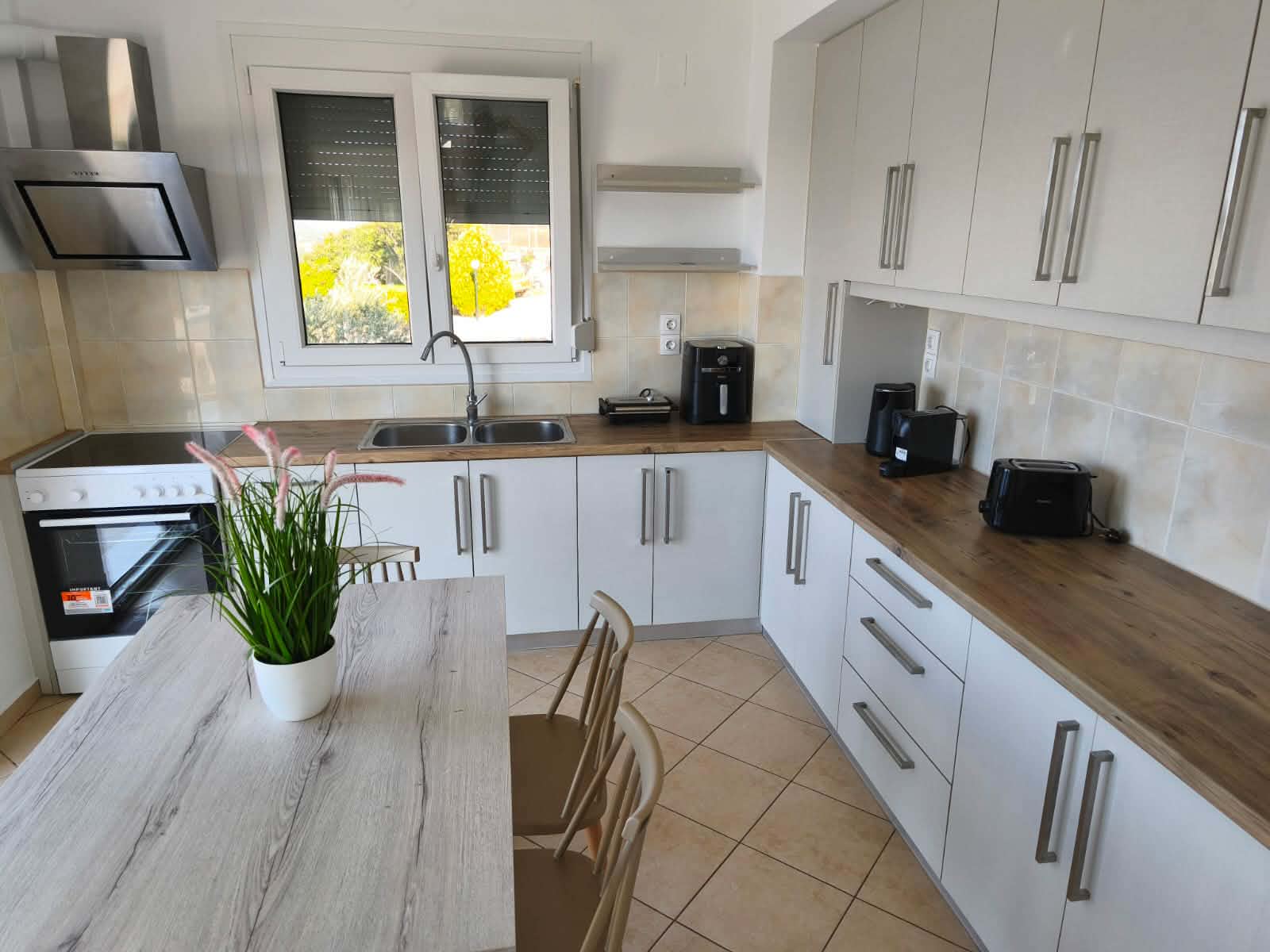 Kitchen with white cabinetry, wood counter & appliances