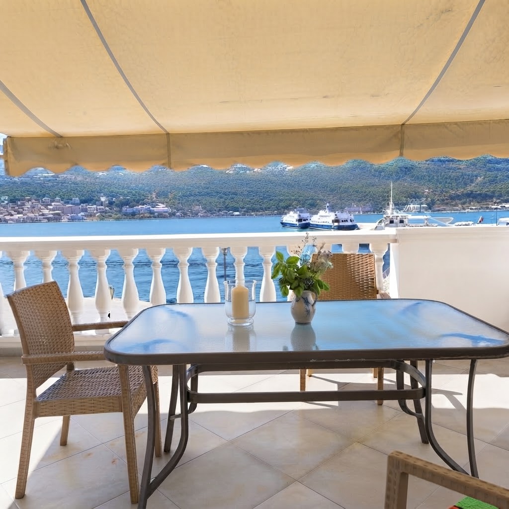Terrace with dining table, candles & basil overlooking the port