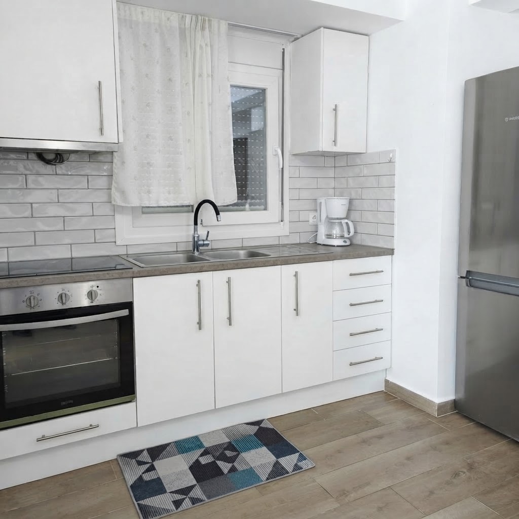Kitchen with white cabinetry, cooktop & filter coffee machine