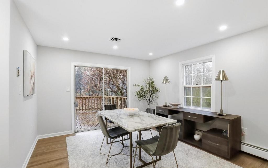 Dining room with marble table, grey chairs and wood flooring by sliding door