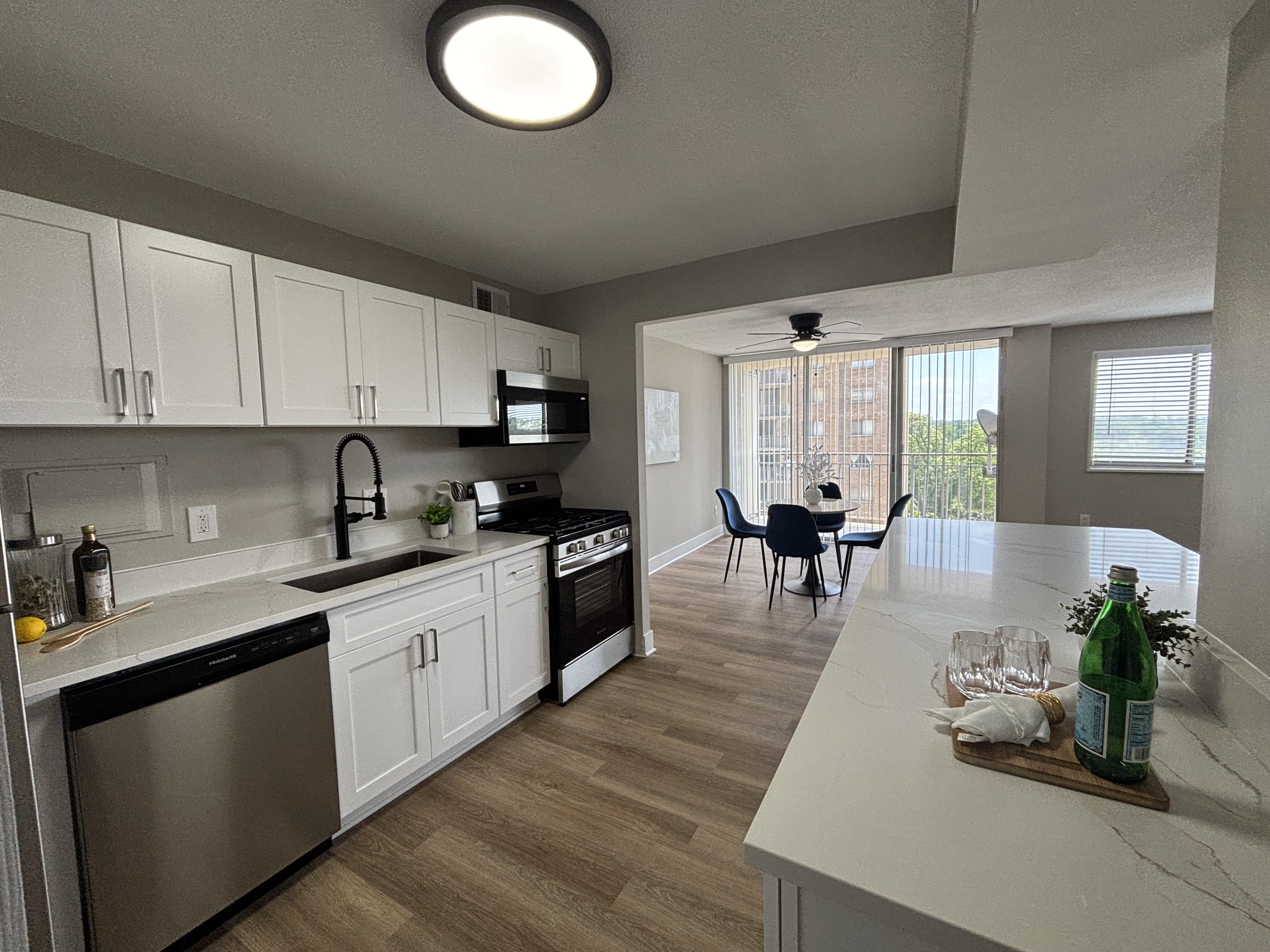 Bright white shaker kitchen with island, matte black faucet and dining area