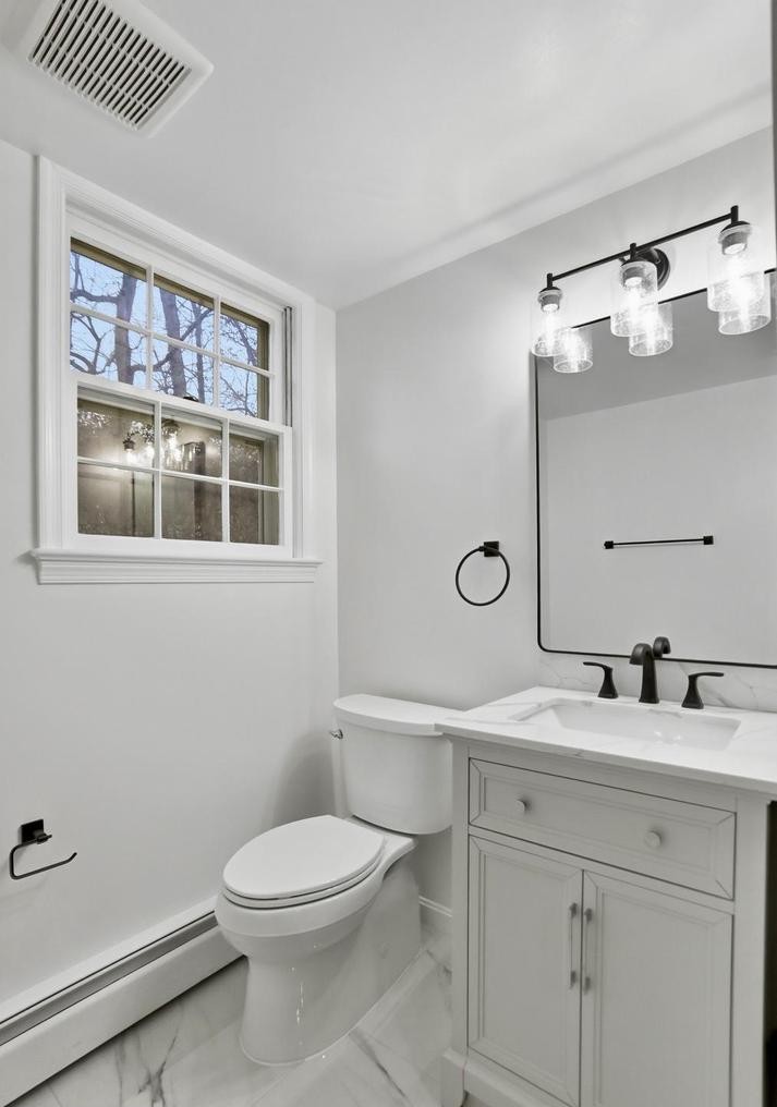 Powder room vanity with black fixtures, Edison vanity light and grid window