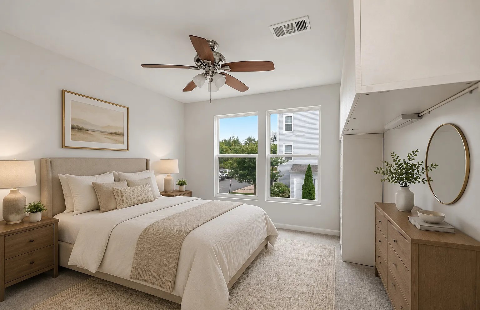 Bedroom with beige headboard, twin windows, wood dresser and vintage rug