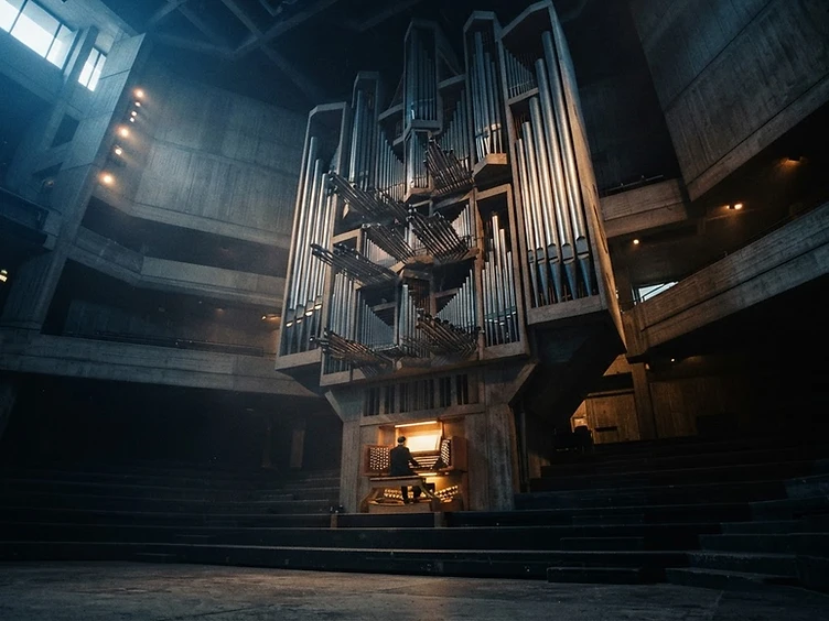 Pipe organ in a brutalist hall, cinematic lighting
