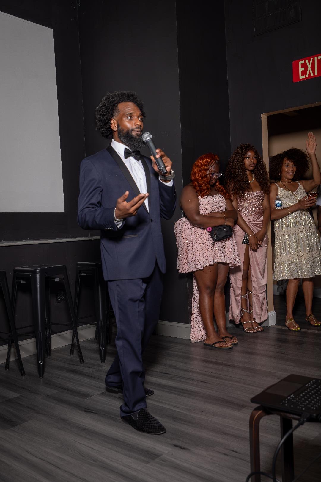 The evening's host speaking on a microphone in the screening room