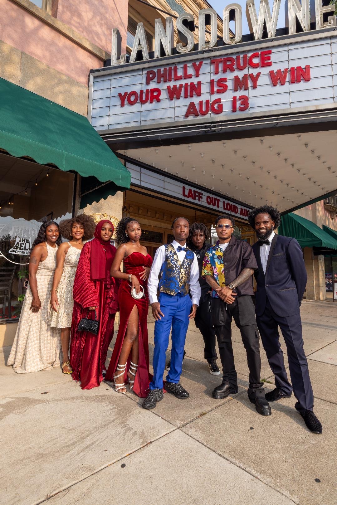 Cohort members in formal attire beneath the Lansdowne Theater marquee