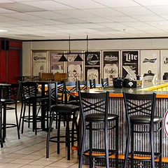 Bar stools, lounge tables, and the beer cooler inside Winner's Circle Gaming Lounge