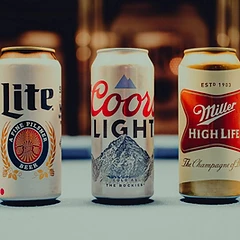 Miller Lite, Coors Light, and Miller High Life cans on the pool table