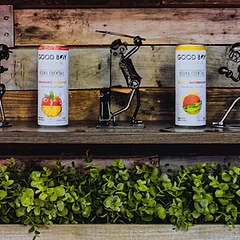 Good Boy Vodka Cocktails displayed on a wood shelf with metal wire figurines