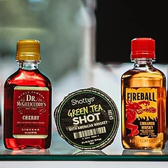 Single-serve liquor bottles including Fireball, Bird Dog, and Shottys