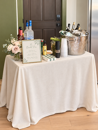 Styled tabletop cocktail station with a framed The Bridal Pour menu, fresh florals, and an ice bucket
