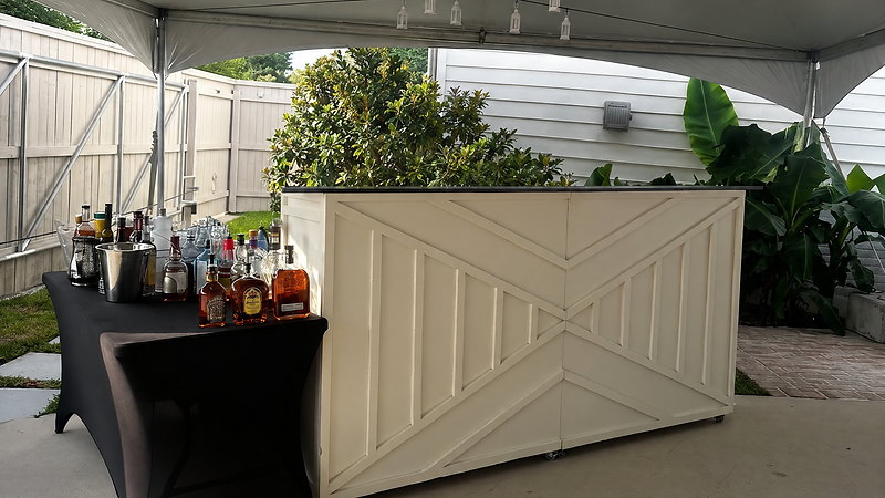 Crisp white geometric paneled bar staged and guest-ready under a tent