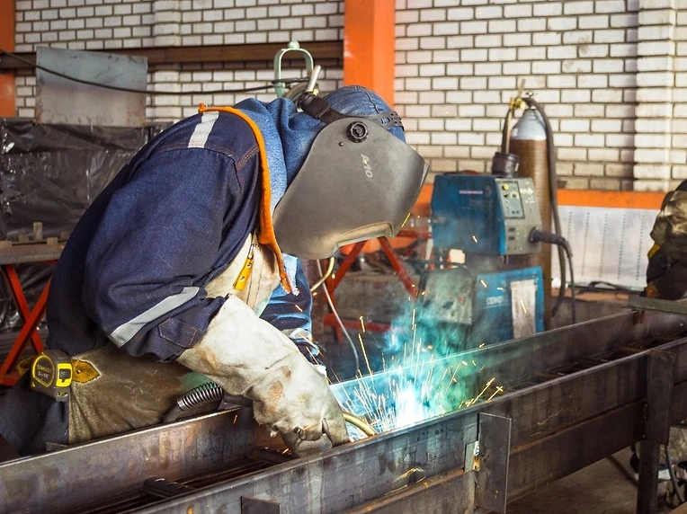 Welder working on a structural beam on-site