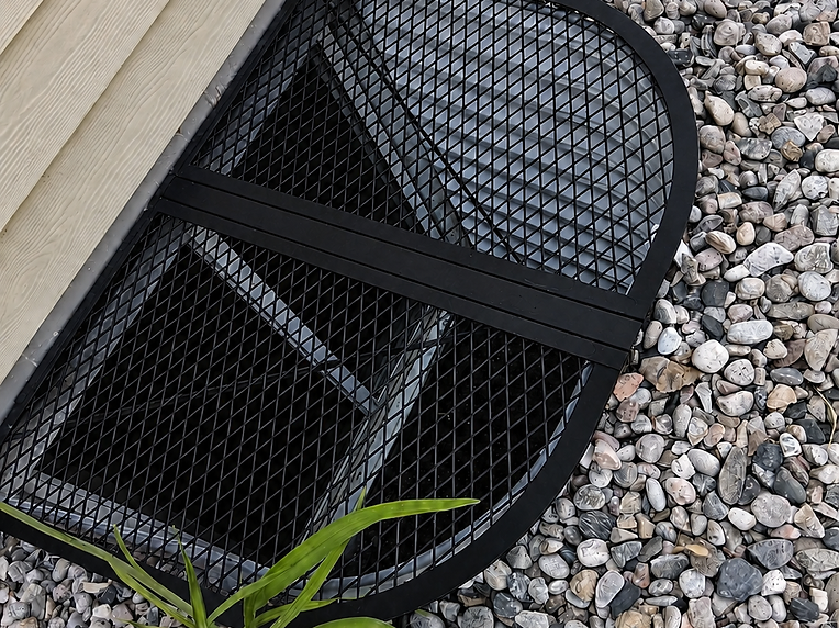 Custom fabricated window well cover installed against a home