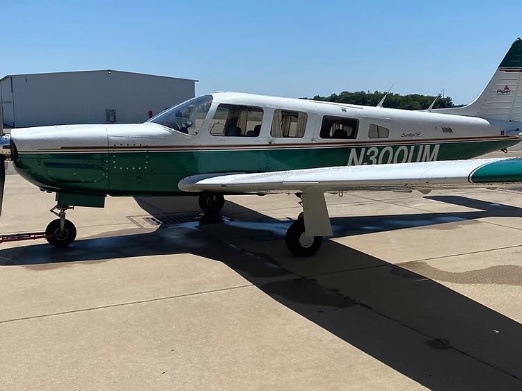 1979 Piper Saratoga SP N300UM in white and green livery parked on the Murray Air ramp