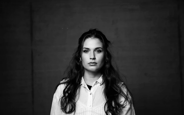 Schwarz-weiss Porträt von Celia Pierina vor dunkler Studio-Wand