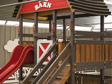 The Barn play structure with a red slide at the covered children's play area, Creative Gardens Bushmills