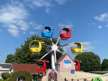Miss Rabbit's Helicopter Flight ride at Peppa Pig World, with colourful helicopter carriages rotating around a central pillar