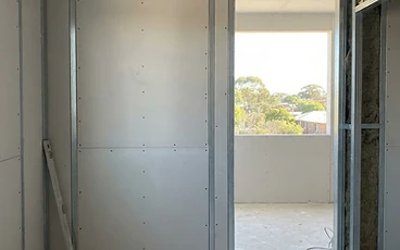 Plasterboard fixed to stud framing during dry lining