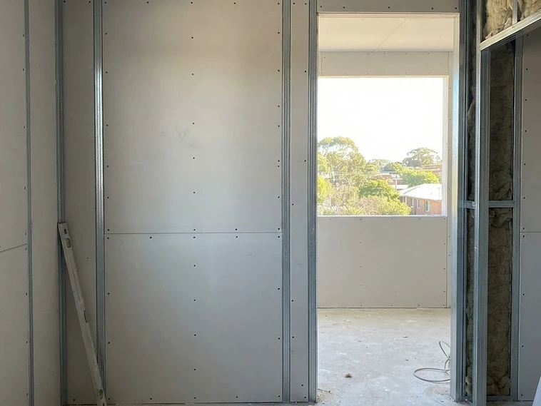 Plasterboard fixed to stud framing during dry lining