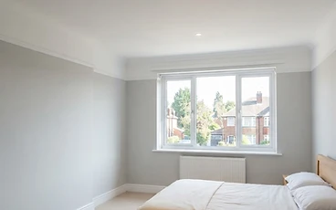 Newly plastered bedroom ceiling after water damage repair