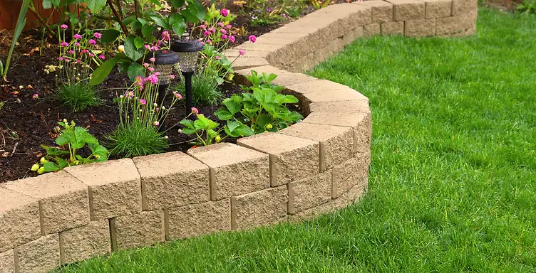 Newly installed stone retaining wall terracing a sloped residential yard in the South Carolina Lowcountry