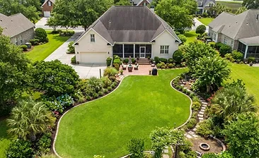Lush green Lowcountry residential garden with healthy lawn and mulched landscape beds