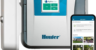 Hunter HPC Wi-Fi smart irrigation controller mounted on a wall beside a smartphone running the Hydrawise app showing watering zones and notifications