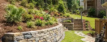 Newly installed stone retaining wall terracing a sloped residential yard in the South Carolina Lowcountry