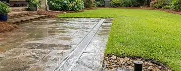 Residential backyard in the South Carolina Lowcountry showing standing water after heavy rain, illustrating a drainage problem
