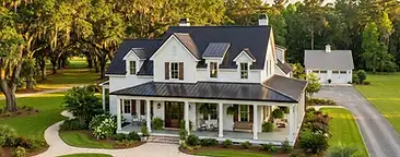Classic southern farmhouse on expansive green land in the Moncks Corner area of the South Carolina Lowcountry with mature oak trees and a large wraparound porch