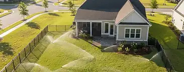 Nexton backyard with a newly installed underground irrigation sprinkler system watering a fresh green lawn in South Carolina