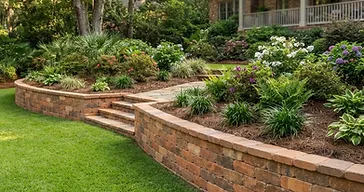 Finished retaining wall built with warm terracotta-colored manufactured stone blocks in a southern Lowcountry residential yard
